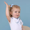 Child wearing a patterned bib against a blue background