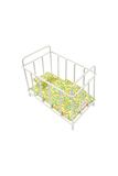 A white metal doll crib or miniature bed frame with a yellow and green floral-patterned mattress, shown on a plain white background.
