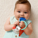 Baby holding a colorful teething toy against a beige background