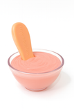 Pink dessert in a clear glass bowl with a pink spoon on a white background