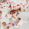 Wooden baby rattle on floral fabric with a book underneath