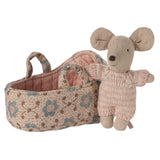 A small plush mouse toy in a knitted pink and beige outfit standing beside a fabric basket with a floral pattern in beige, blue, and brown on a white background.