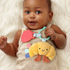 Baby holding a colorful toy with a soft white background