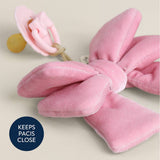 Pink velvet bow pacifier clip on a light background