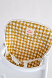 Yellow and white checkered chair pad with 'tiny harlow' brand on a white background