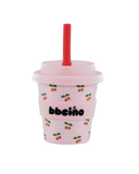Pink tumbler with cherry pattern and red straw on a white background