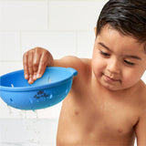 Child playing with a blue bath toy in a bathroom setting