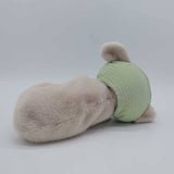 Plush toy resembling a dog with a green body and beige head on a white background