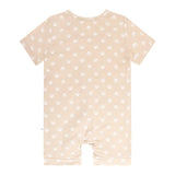 Beige baby romper with white polka dots on a white background