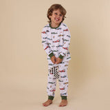 Child wearing a pajama set with car pattern on a beige background