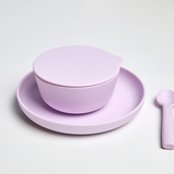 Purple ceramic bowl and plate set on a light gray background