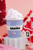 Cup of cotton candy with a decorative label on a pink background
