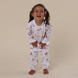 Child wearing a floral pajama set on a beige background