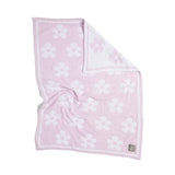 Pink towel with white floral pattern on a white background