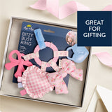 Baby teething ring set in a box with decorative elements on a light background