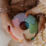 Children playing with a colorful baby teething ring.