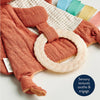 Textured orange baby blanket with a white ring on a neutral background