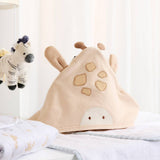 Beige animal-shaped pillow on a bed with a zebra plush toy in the background