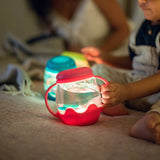 Children playing with colorful light-up toys on a soft surface