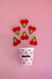 Paper cup with cherry design on a pink background