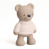 Beige teddy bear wearing a white sweater on a white background