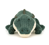 Green plush toy alligator on a white background