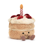 Plush toy cake with a candle on a white background
