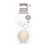 BIBS Pacifier Case Mini in a warm cream color, shown inside its original white and gray cardboard packaging on a solid white background.