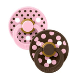 Two baby pacifiers with polka dot designs on a white background