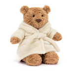 Teddy bear wearing a cream robe on a white background