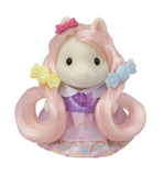 Toy figure with pink hair and a colorful dress on a white background