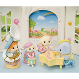 Toy figurines of animals playing musical instruments in a decorative setting with a rainbow and garden.