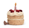 Plush toy resembling a birthday cake with a candle on a white background