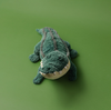Plush toy alligator on a green background